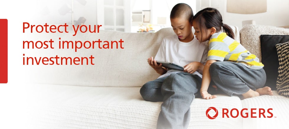 An image of two children using an iPad on a couch