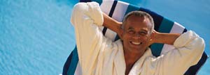 Man resting next to swimming pool