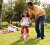 Niña aprendiendo a andar en triciclo