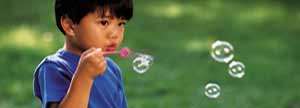 Young boy blowing bubbles
