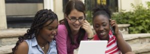 Three teens looking at laptop computer
