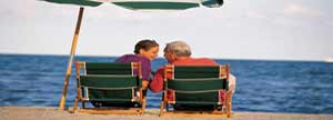 Couple talking to each other under an umbrella at the beach
