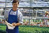 Man taking inventory in a greenhouse.