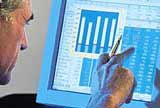 A man studying charts on a computer monitor.