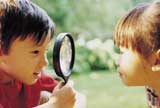 Two children looking through magnifying glass