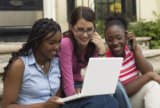 Three teens looking at laptop computer