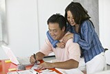 Smiling couple working at laptop