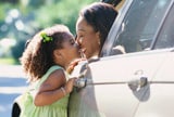 Daughter kissing mother in car 