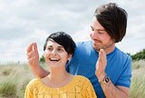 Couple in a grassy field having fun