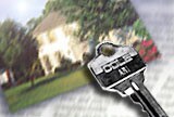 Image of key in front of photo of house