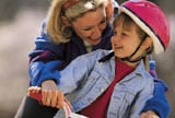 mother helping son ride a bike