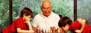 Un homme joue aux échecs avec ses petits-fils