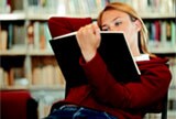 Une étudiante lit à la bibliothèque