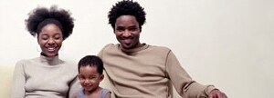Family smiling sitting on a couch