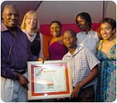 William 'Bill' Clarke presents Kord Campbell with a certificate as well as his scholarship