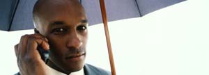 businessman with umbrella talking on cell phone