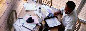 Man hard at work with many papers near him