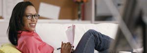 Woman sitting on couch writing