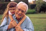 Elderly man carrying his granddaughter