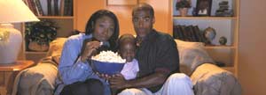 Family watching TV with popcorn