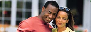 Man holding his wife with their new home behind them