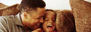 Man playing with his son in a sofa