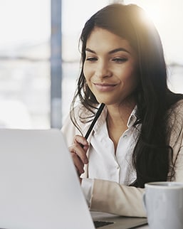 Professional woman with a pen at her computer