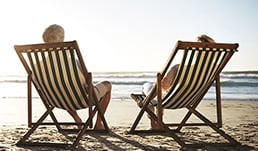 A couple on chairs looking out at the beach