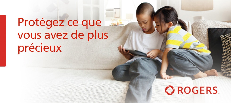 An image of two children using an iPad on a couch