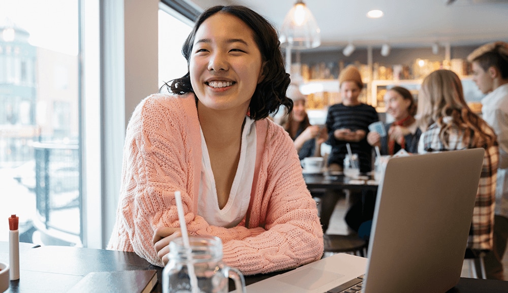 Women sitting in cafe by her laptop.