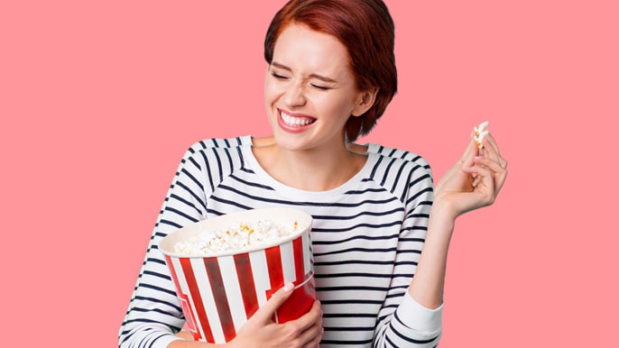 happy woman with popcorn bucket