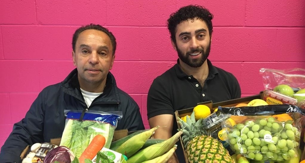 Des hommes avec des paniers de fruits et de légumes.