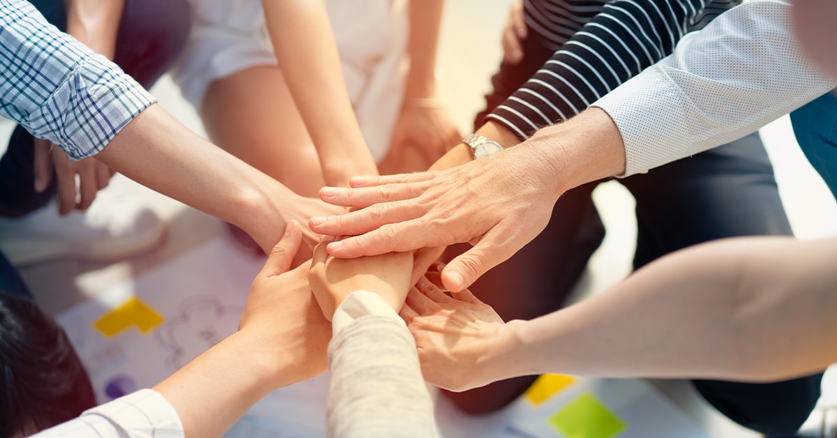 People in circle putting hands together