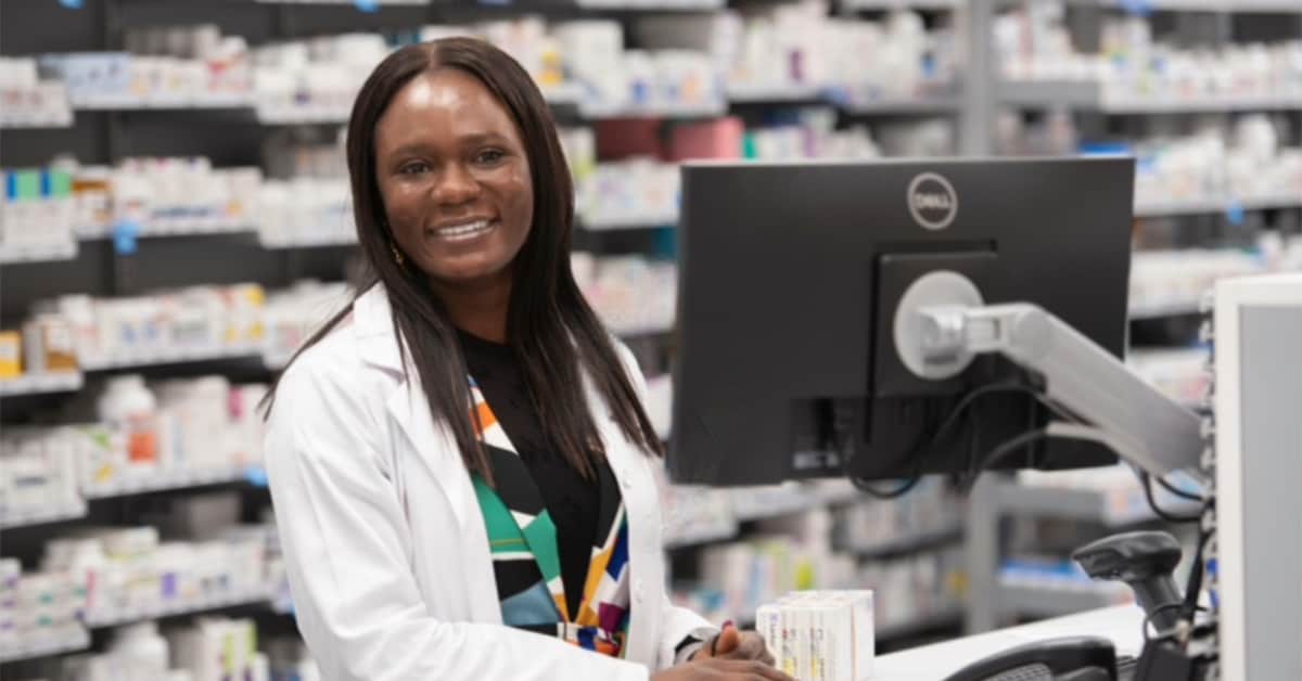 Pharmacist at desk smiling