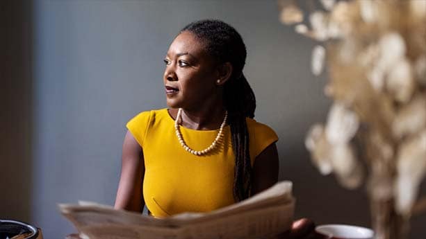 A businesswoman holding a newspaper.