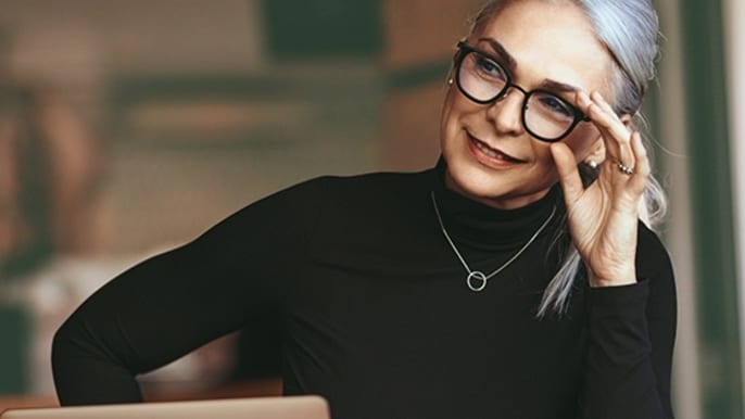 A white-haired woman using a laptop.