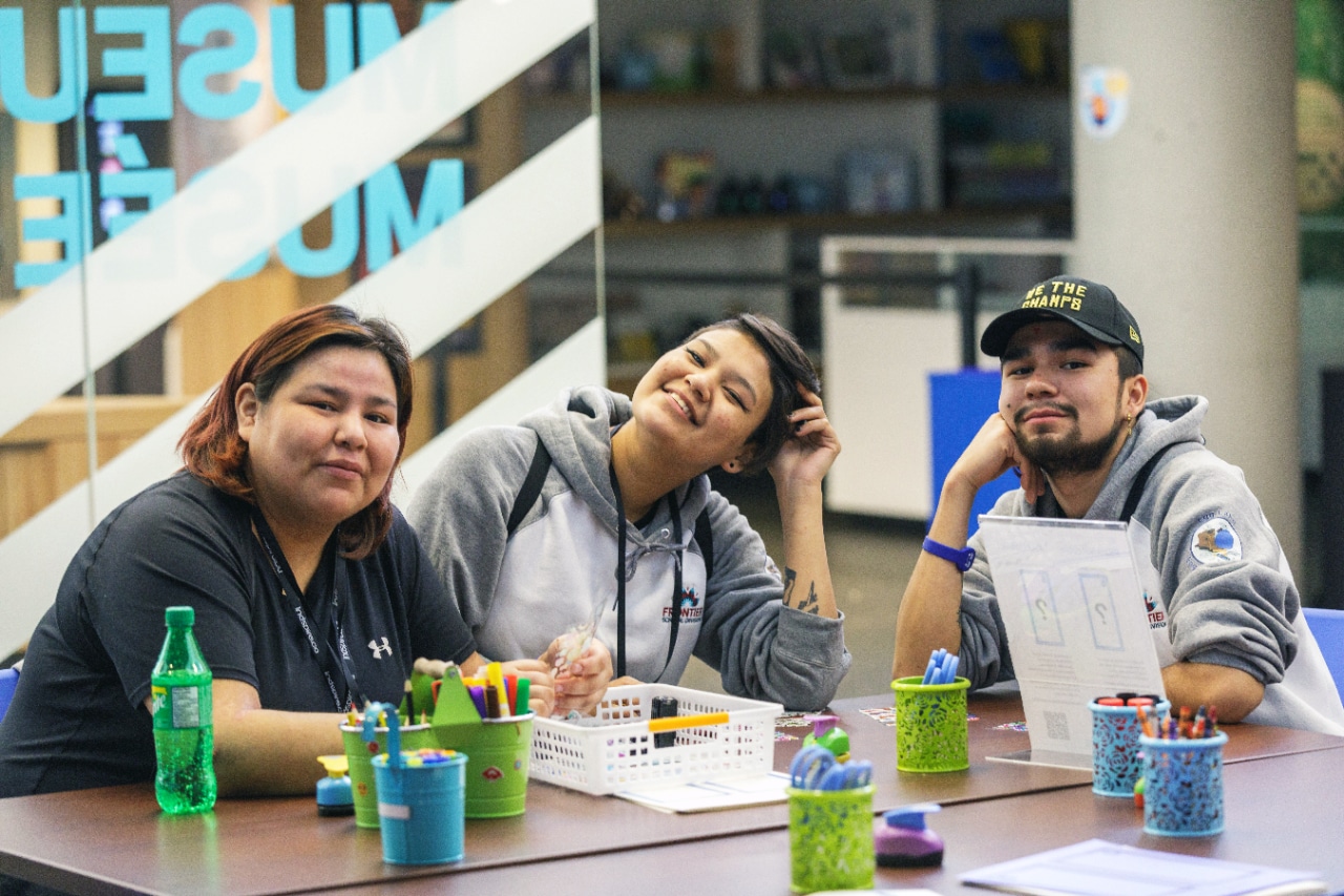Three people sat at table
