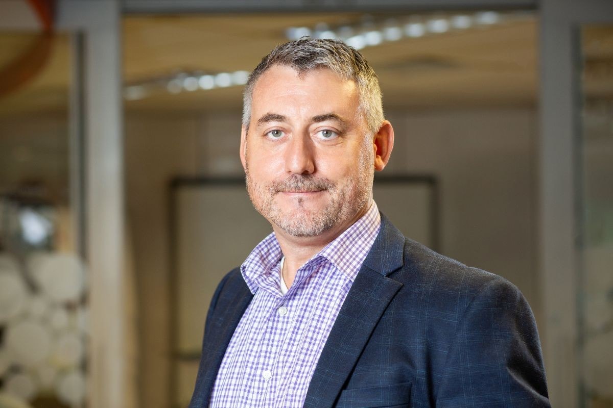 Portrait de Winston Morton en blazer dans un bureau